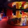 Exposition colorée avec mannequins et éclairage vibrant.