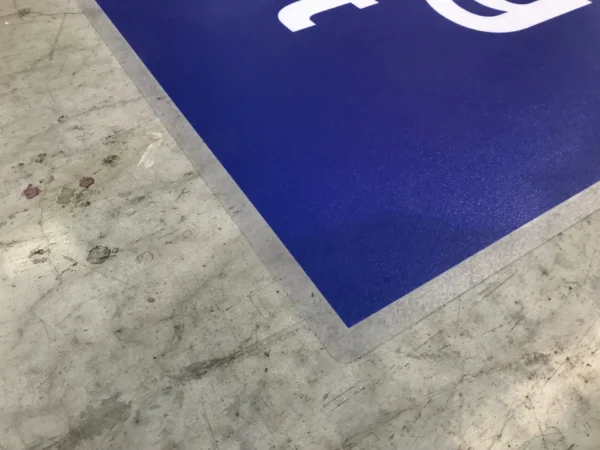 Coin d'un tapis bleu sur sol gris